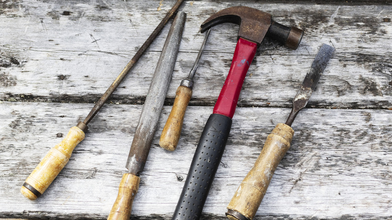 metal and wooden tools sitting on wooden surface