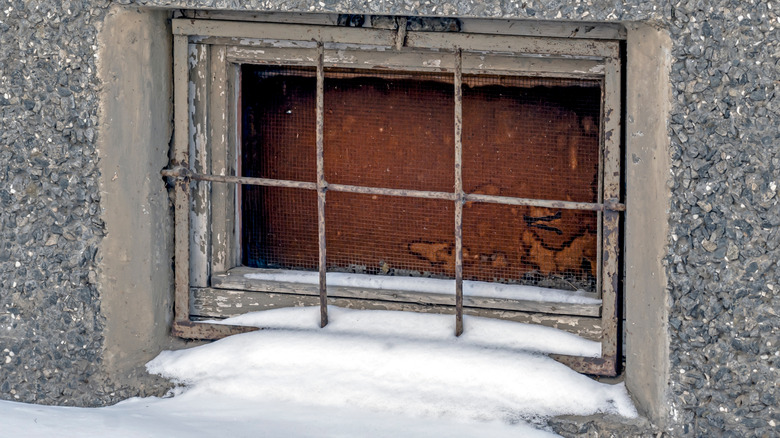 snow building up around old basement window