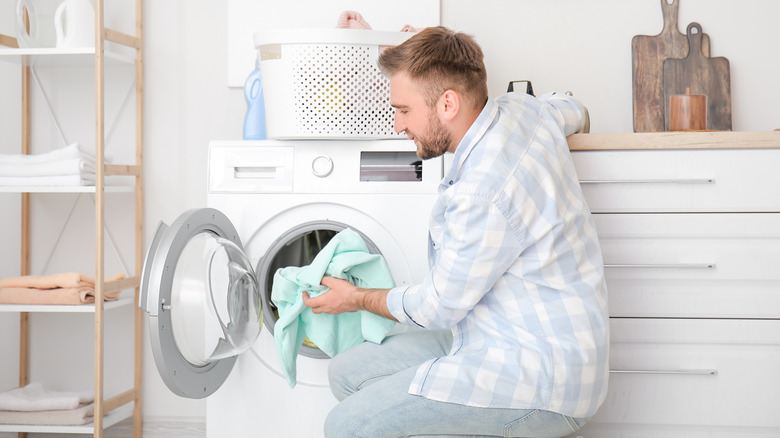 Man unloading laundry from dryer