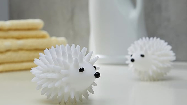 Kikkerland Hedgehog Dryer Balls in a laundry room next to folded linen