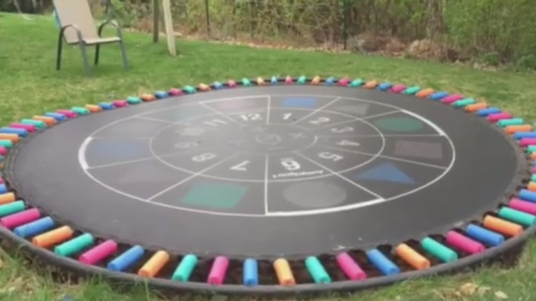 multicolored pool noodles as trampoline spring covers