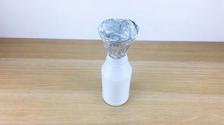 Aluminum foil funnel in white bottle