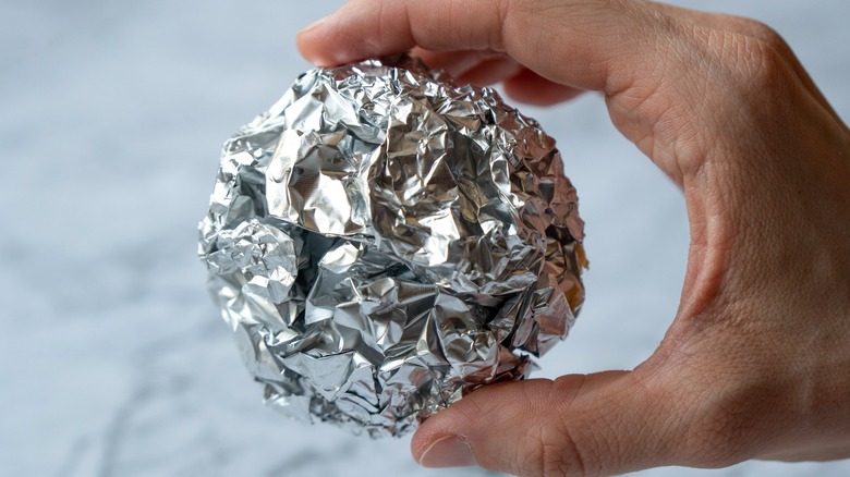 Hand holding aluminum ball 