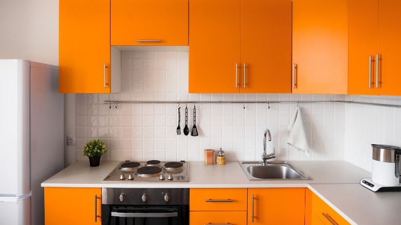 Orange cupboards in white kitchen