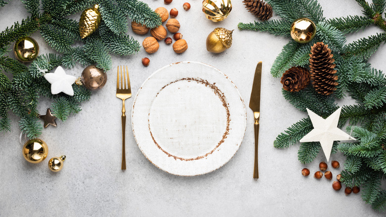 greenery, pinecones, and white plates