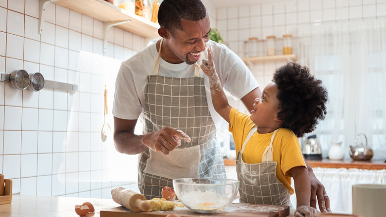 man and child wearing matching aprons