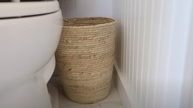 Jute trash can next to toilet