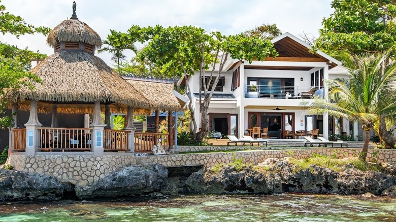 home with grass-roofed gazebo