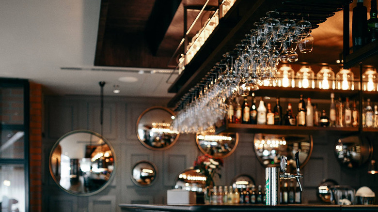 Suspended wine glasses in dark bar