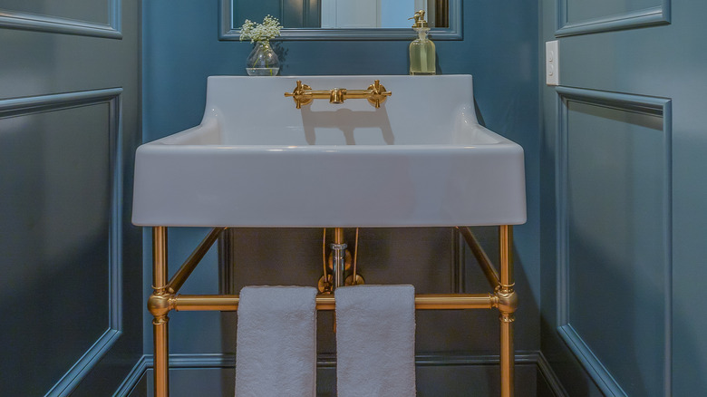 White and gold console sink in blue bathroom