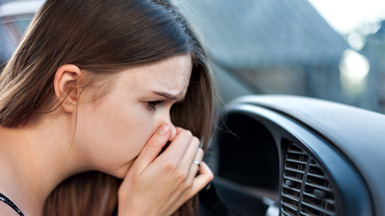 Woman held nose at car vents