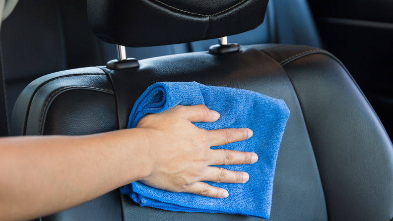 Hand holding towel on car seat