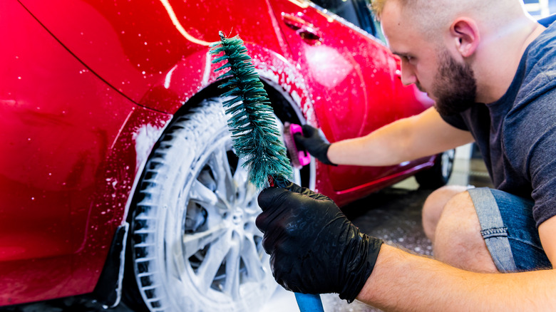 Man brushing rubber tire