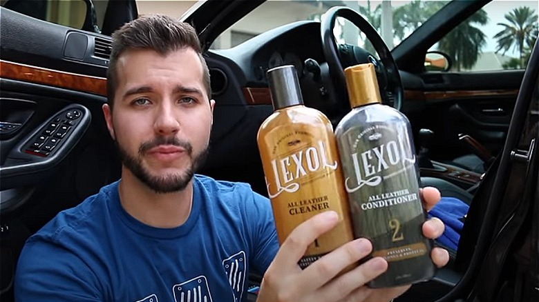 Man holding leather cleaners by a car