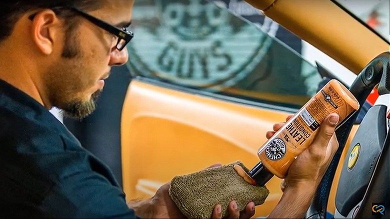 Man in car applying leather conditioner