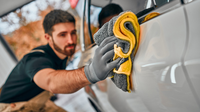 Man wiping car after washing