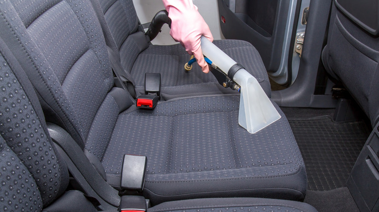 Closeup car seat vacuuming