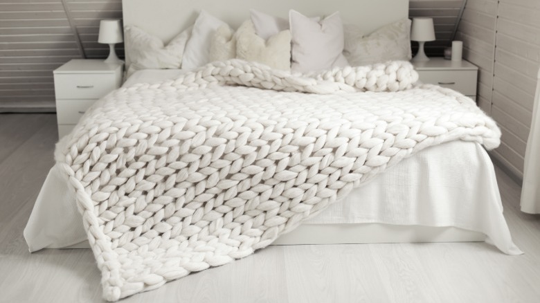 Knitted white blanket on bed