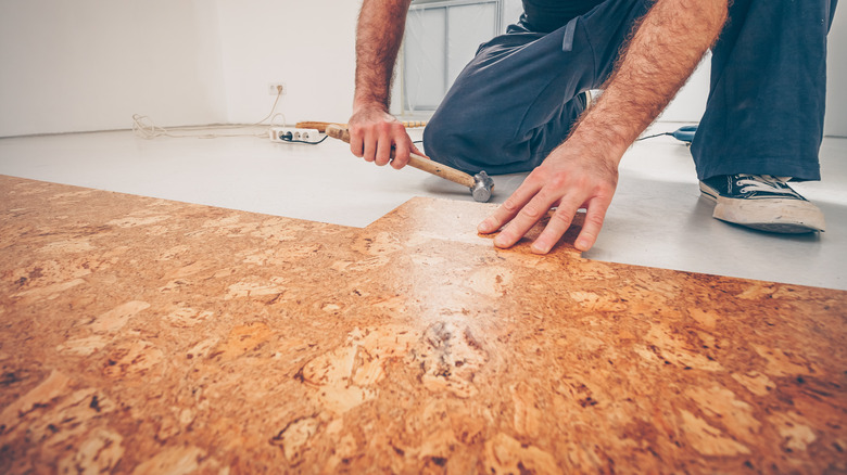 man installing cork flooring