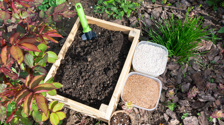 Soil additives next to a raised garden bed