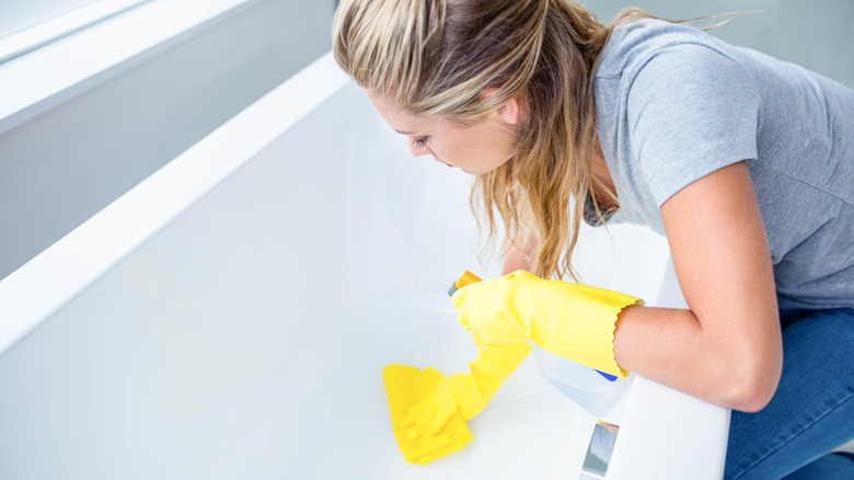 Woman cleaning bathtub