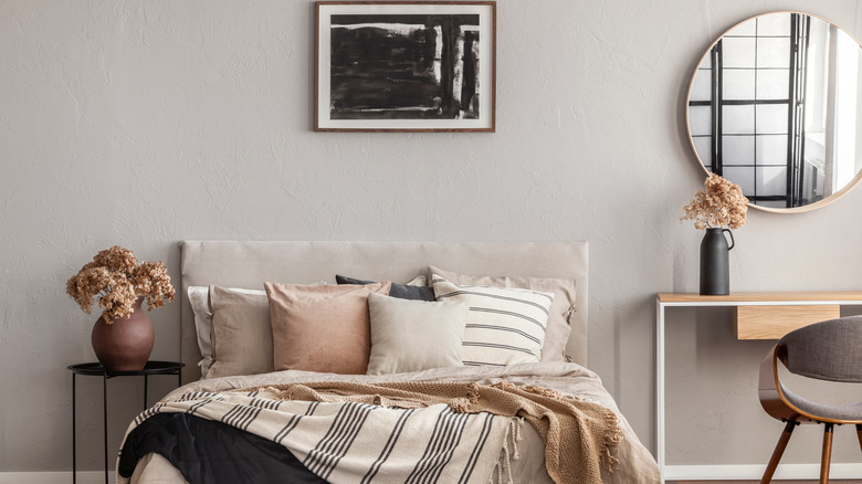 beige bedroom with black art