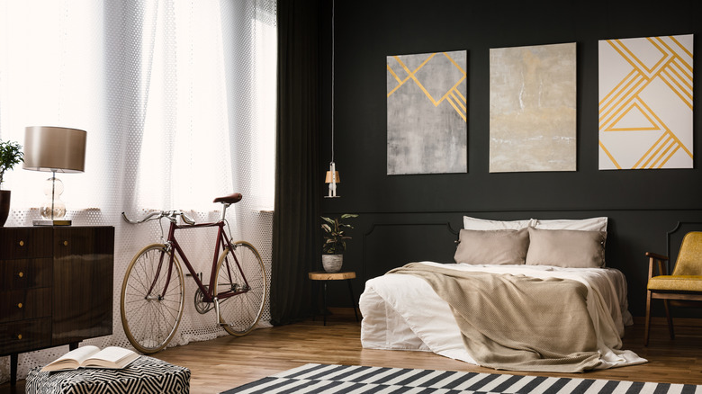 black bedroom with gold art