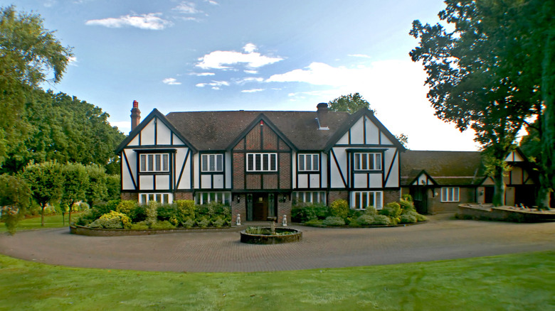 Tudor mansion with grass lawn