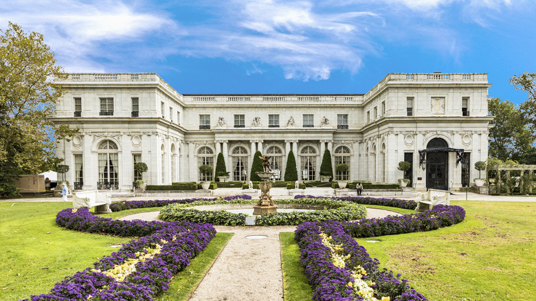 garden of purple flowers in front of a mansion