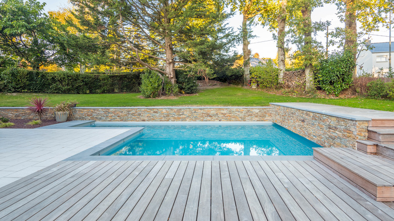 pool with wood, stone, and grass