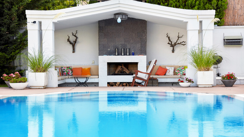 outdoor fireplace beside a pool