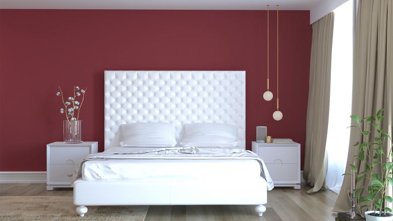 white bedframe against red wall