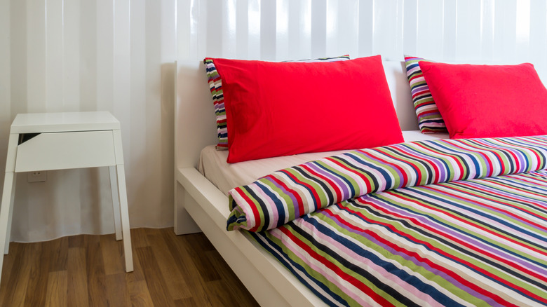 rainbow bedding with red pillows