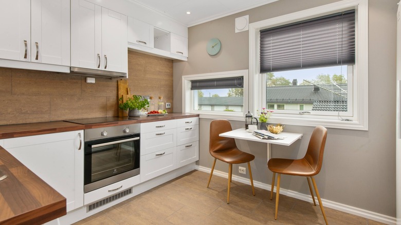 Tan and white kitchen with small table