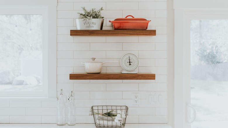 Brown floating shelves in white kitchen