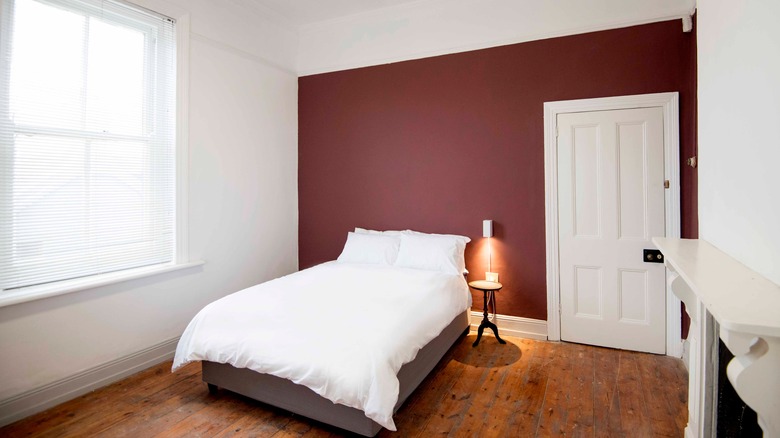 Interior of bedroom with statement wall and wood floors