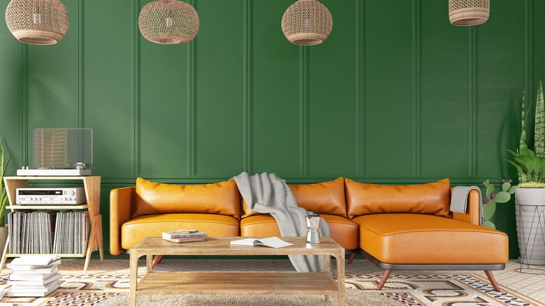 green walls with orange sofa