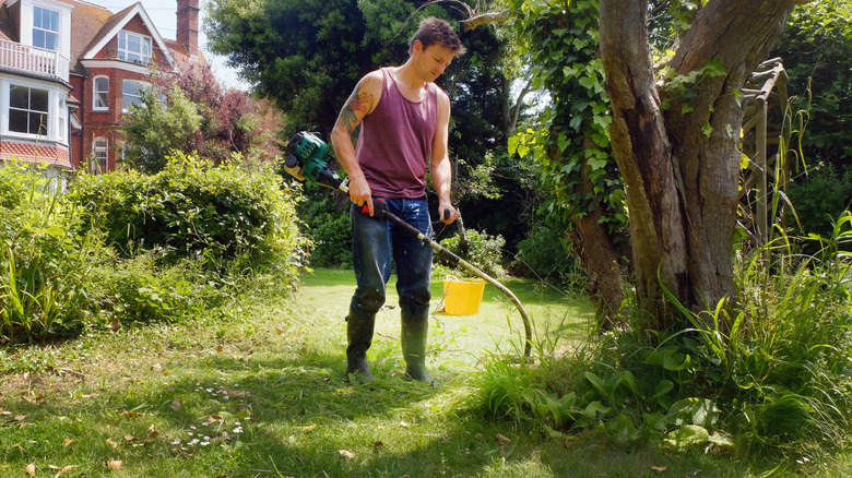 man using a weed whacker