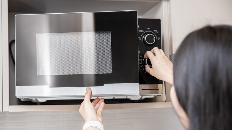 woman opening microwave