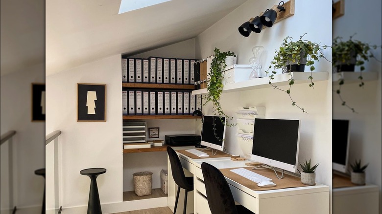 Beautifully decorated home office with sun light, contemporary lamps, and two-person desk