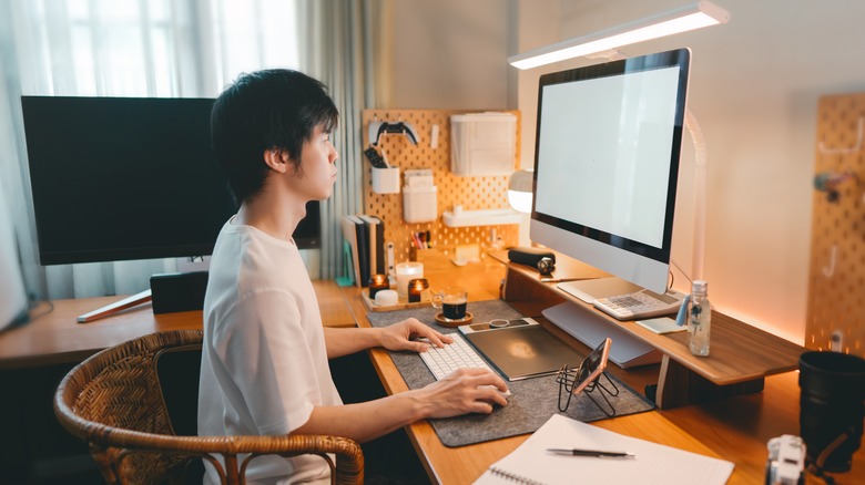 Person working at their home office with a monitor light bar