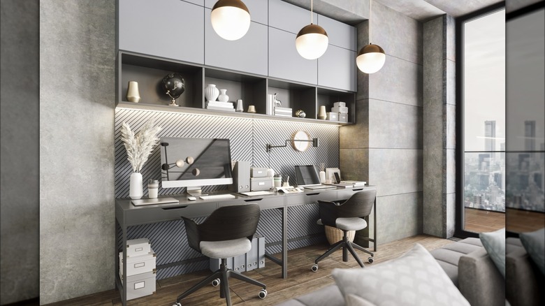 Three pendant lights hanging above gray and black home office desk