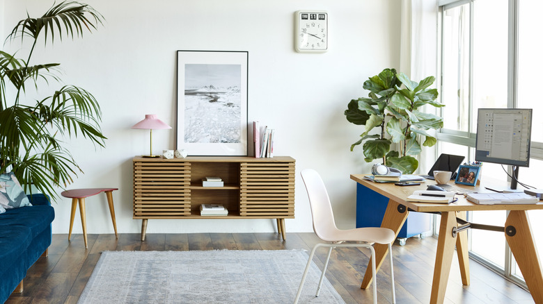 Bright home office where the desk is positioned close to floor-to-ceiling glass windows