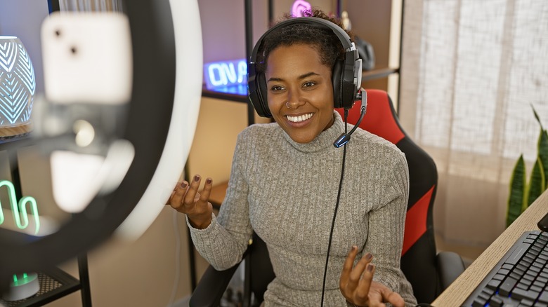 Person sitting at desk with ring light and headphones