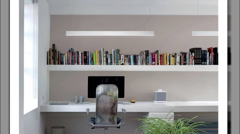 White linear suspension lights above white office desk