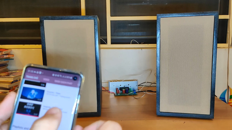 A person testing bookshelf speakers and homemade amplifier