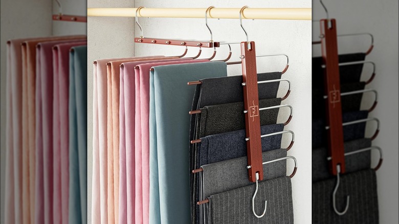 Several pairs of pants hang neatly on specialty pants hangers