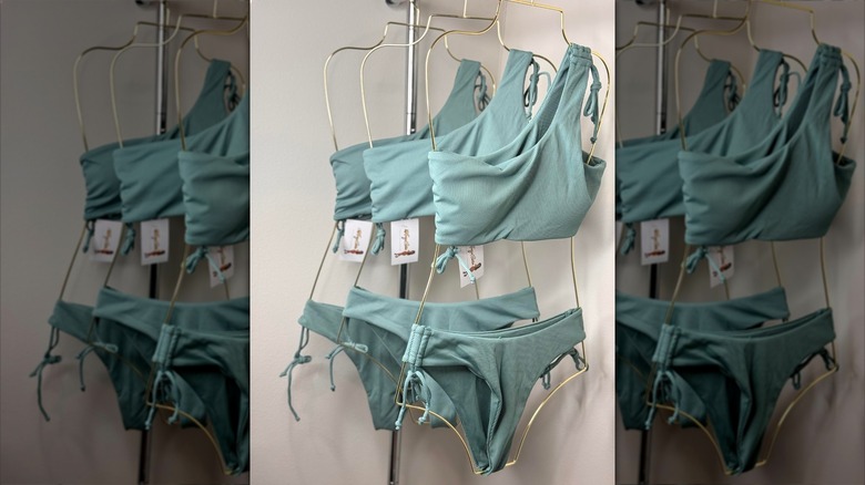 Bikinis are displayed on metal silhouette hangers