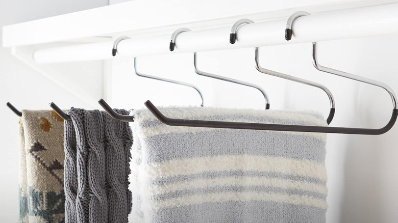 Three knit throws hang from slip-resistant blanket hangers