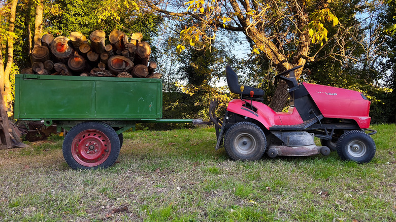 Lawn tractor with trailer full of logs attached